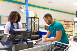 Hombre pasando sus compras por la caja del supermercado